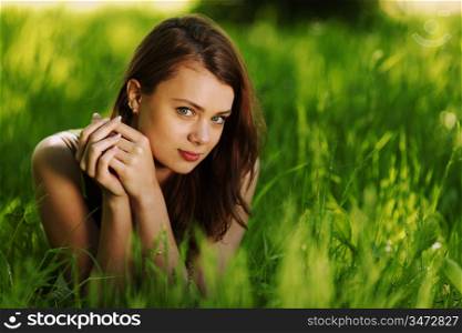 brunette lying on green grass