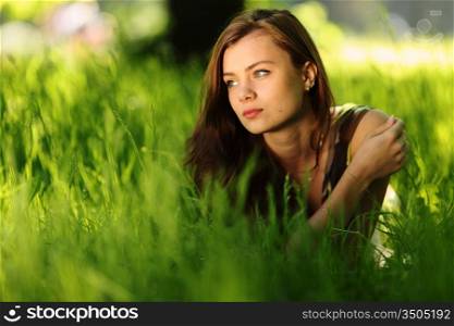 brunette lying on green grass