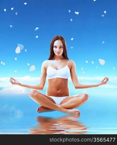 Brunette model in yoga pose and water