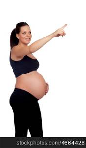Brunette pregnant in black pointing something isolated on a white background