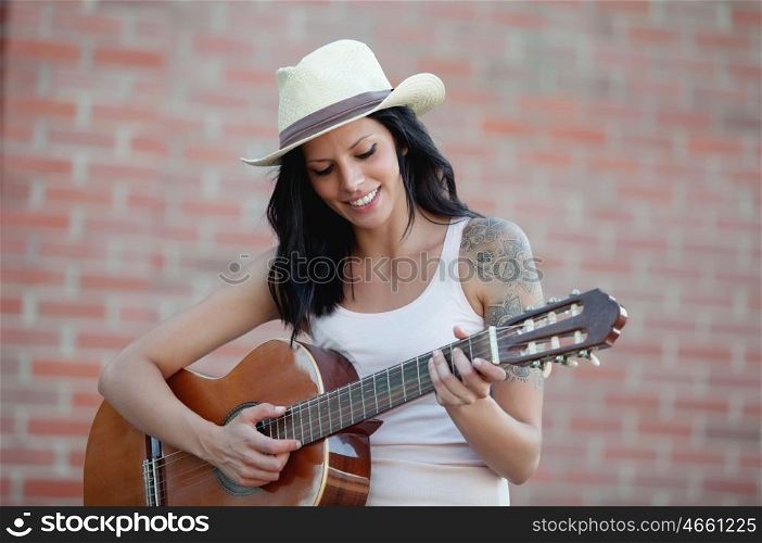 Brunette pretty woman playing a clasic guitar