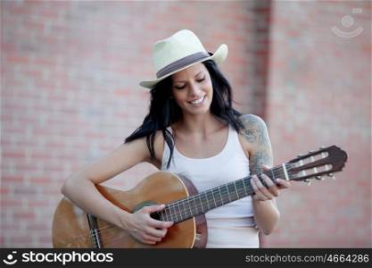 Brunette pretty woman playing a clasic guitar