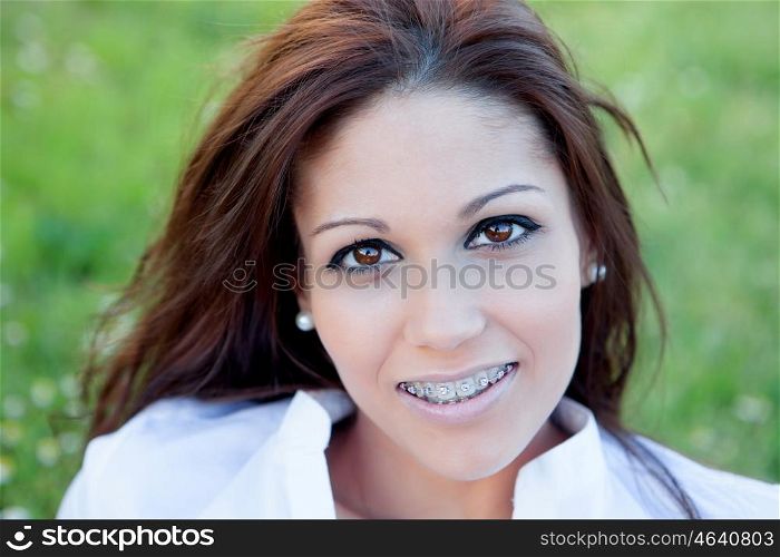 Brunette pretty woman with brackets relaxing in the park