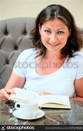 Brunette reading a book at the table