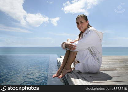 Brunette sat at theend of a jetty