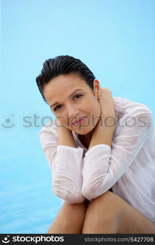 Brunette sat by pool in wet shirt