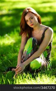 brunette sitting on green grass