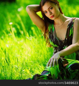 brunette sitting on green grass