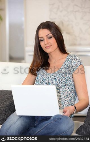 Brunette surfing internet on laptop computer
