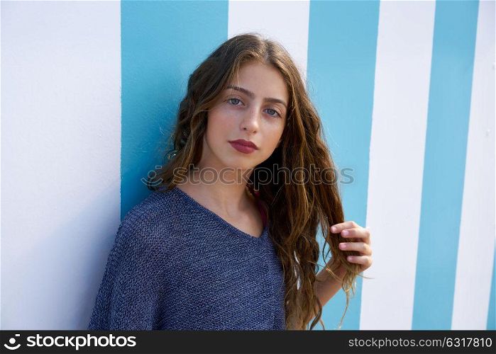 Brunette teen girl portrait in a summer beach blue stripes wall