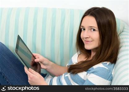 Brunette Teenage Girl Working On A Table PC whole lying on a couch