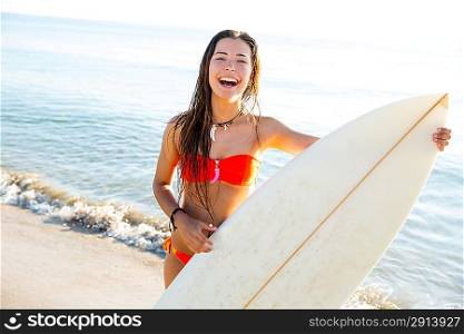 Brunette teenager surfer bikini girl with surfboard on beach shore