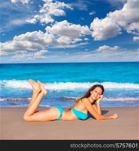 Brunette tourist lying in beach sand tanning happy in summer vacation