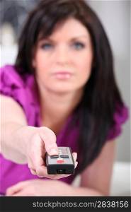 Brunette with a television remote control