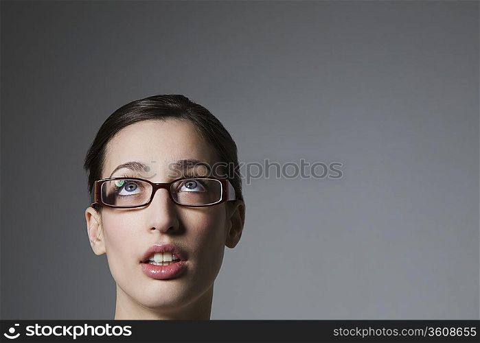 Brunette with blue eyes and spectacles looking up