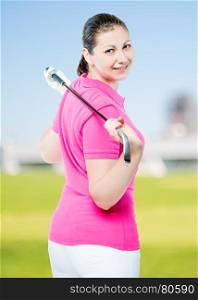 brunette with club golf posing on a background of golf courses