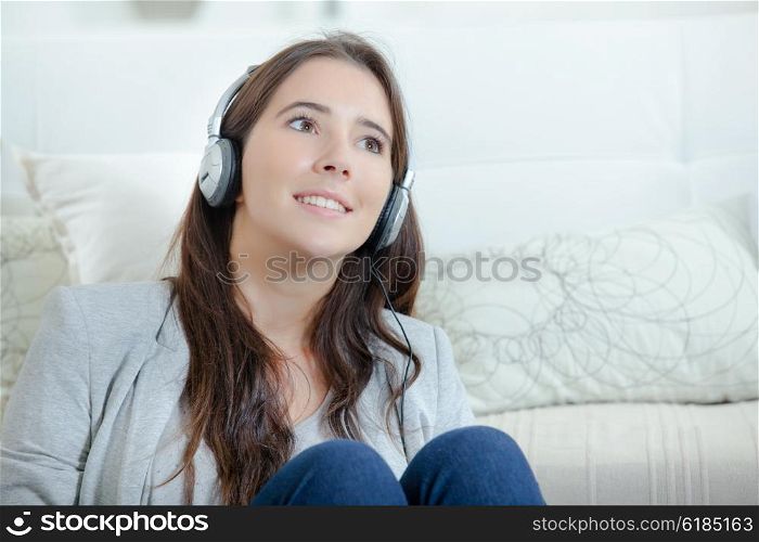 Brunette with headphones daydreaming