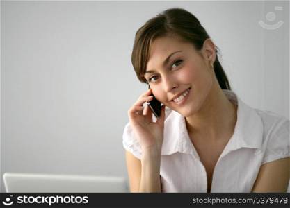 Brunette with laptop making telephone call