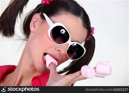 brunette with pigtails and sunglasses eating marshmallows