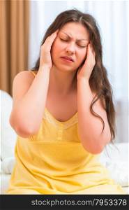 brunette with severe migraine in nightgown