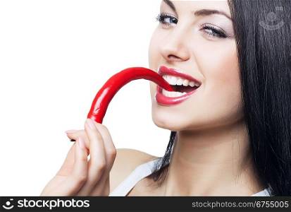 brunette woman biting chili pepper on white background