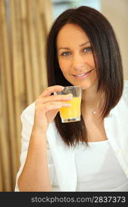 brunette woman drinking orange juice
