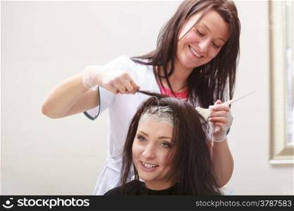 Brunette woman in hairdressing beauty salon. Girl dying hair by hairstylist. hairdresser colouring client hair.