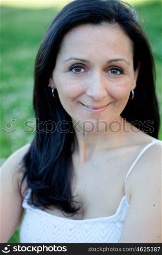 Brunette woman looking at camera on a flowered meadow