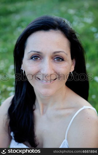 Brunette woman looking at camera on a flowered meadow