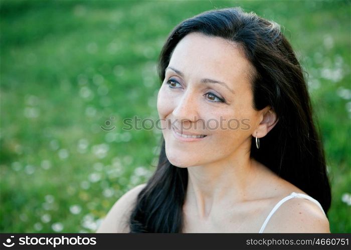 Brunette woman looking at side on a flowered meadow