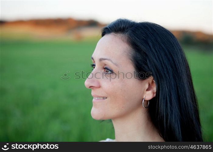 Brunette woman looking at side relaxing on a meadow