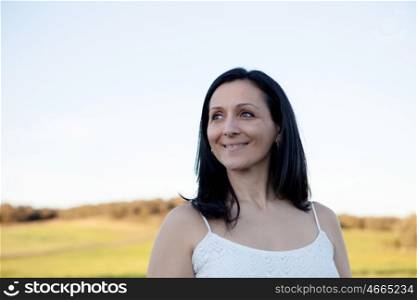 Brunette woman looking at side relaxing on a meadow
