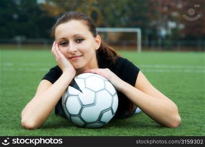 Brunette woman lying down with football