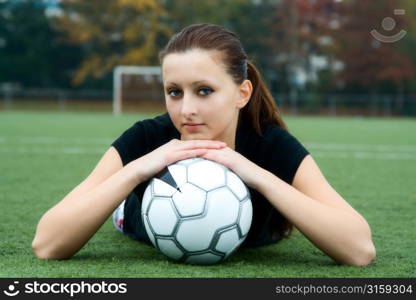 Brunette woman lying down with football