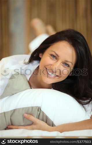 brunette woman lying on bed