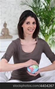 brunette woman taking a little globe in her hands
