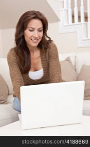 Brunette Woman Using Laptop Computer At Home on Sofa