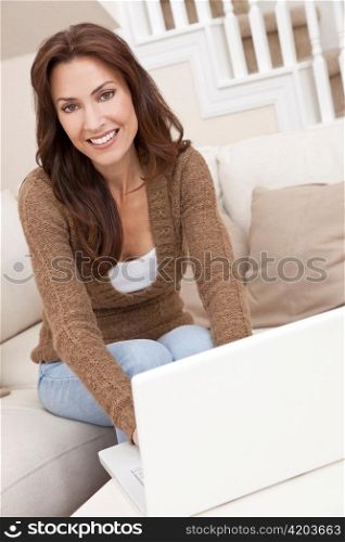 Brunette Woman Using Laptop Computer At Home on Sofa