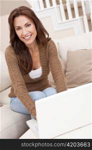 Brunette Woman Using Laptop Computer At Home on Sofa