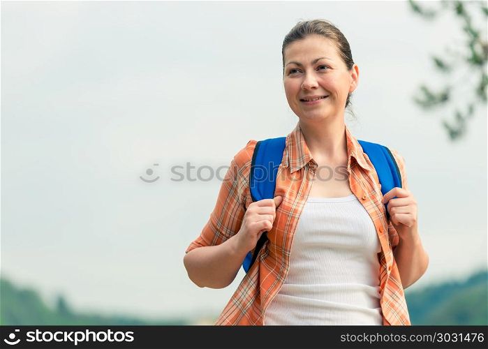 brunette woman with a backpack on the nature in a hike