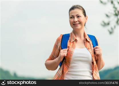 brunette woman with a backpack on the nature in a hike