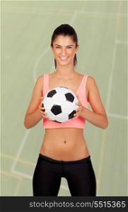 Brunette woman with a ball on a soccer field of background