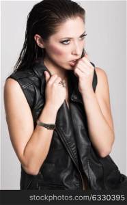 Brunette woman with blue eyes wearing black leather jacket and panties on white background. Studio shoot