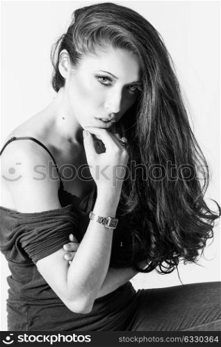 Brunette woman with blue eyes wearing sweater and blue jeans on white background. Studio shoot