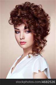 Brunette woman with curly and shiny hair. Beautiful model with wavy hairstyle. Fashion photo