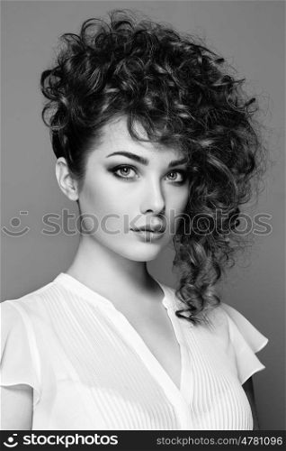 Brunette woman with curly and shiny hair. Beautiful model with wavy hairstyle. Fashion photo. Black and White