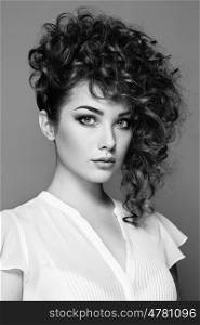 Brunette woman with curly and shiny hair. Beautiful model with wavy hairstyle. Fashion photo. Black and White
