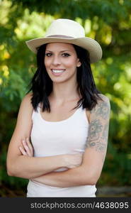 Brunette woman with straw hat walking through the woods