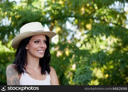 Brunette woman with straw hat walking through the woods