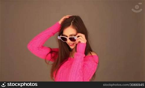 Brunette woman with sunglasses holding her hair